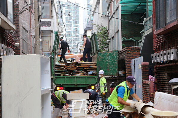  군포시방범기동순찰연합대원들이 수해복구 현장을 돕고있다(사진제공=군포시)