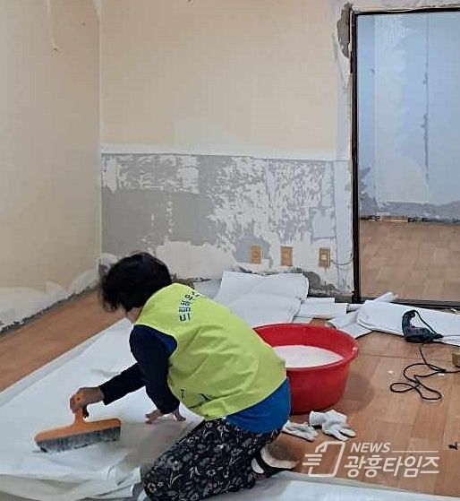 드림하우스 봉사단원이 주거 상향 지원사업 대상자의 가구에서 도배 봉사를 하고 있다